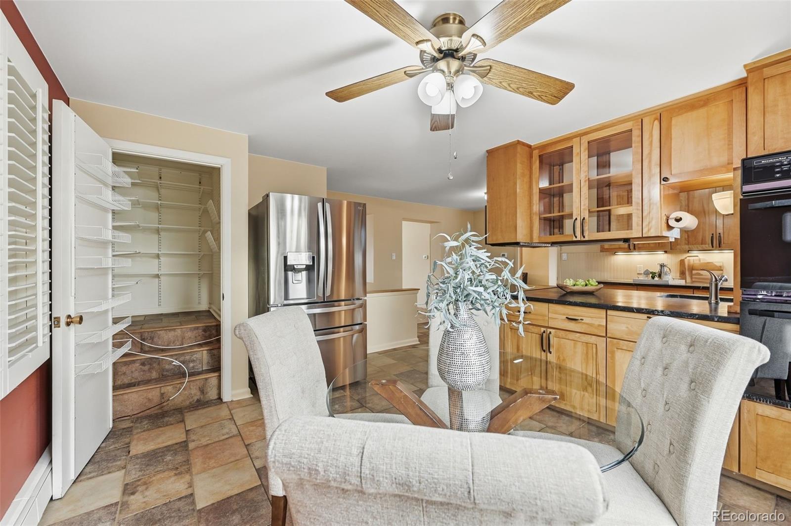 2002 West Ridge Road Littleton, CO 80120 - Photo 13 of 50 a kitchen with stainless steel appliances granite countertop a refrigerator a stove a microwave oven with a dining table and chairs