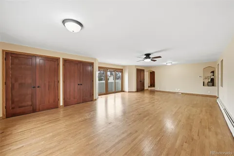 an empty room with wooden floor and windows