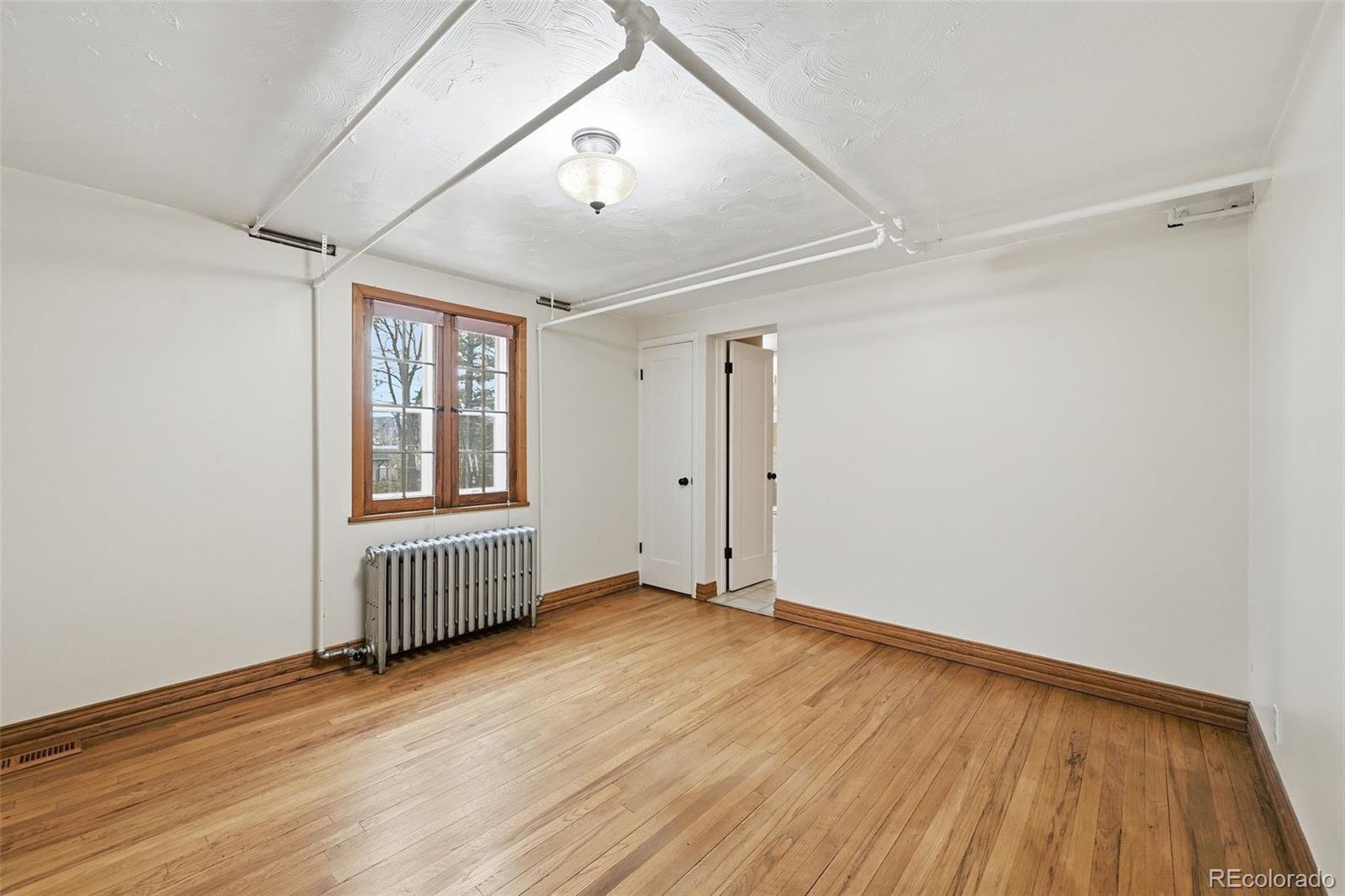 2002 West Ridge Road Littleton, CO 80120 - Photo 26 of 50 an empty room with wooden floor and windows