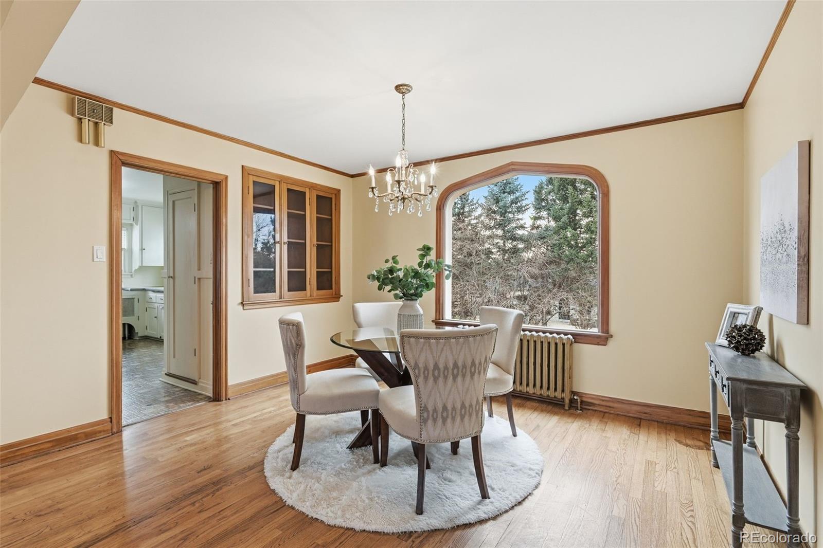 2002 West Ridge Road Littleton, CO 80120 - Photo 6 of 50 a dining room with furniture wooden floor a potted plant and a chandelier