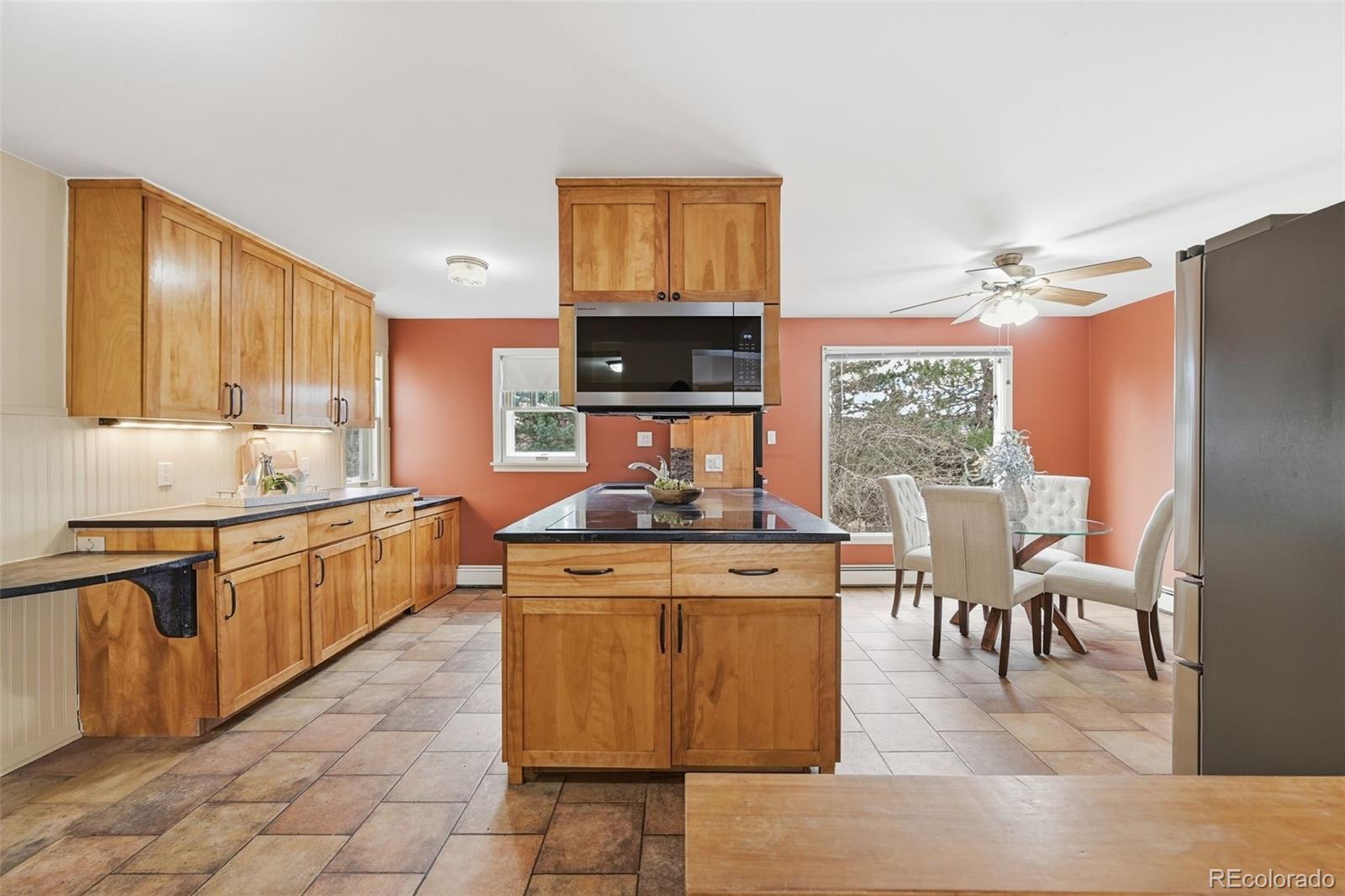 2002 West Ridge Road Littleton, CO 80120 - Photo 9 of 50 a kitchen with stainless steel appliances granite countertop a stove top oven a sink a dining table and chairs