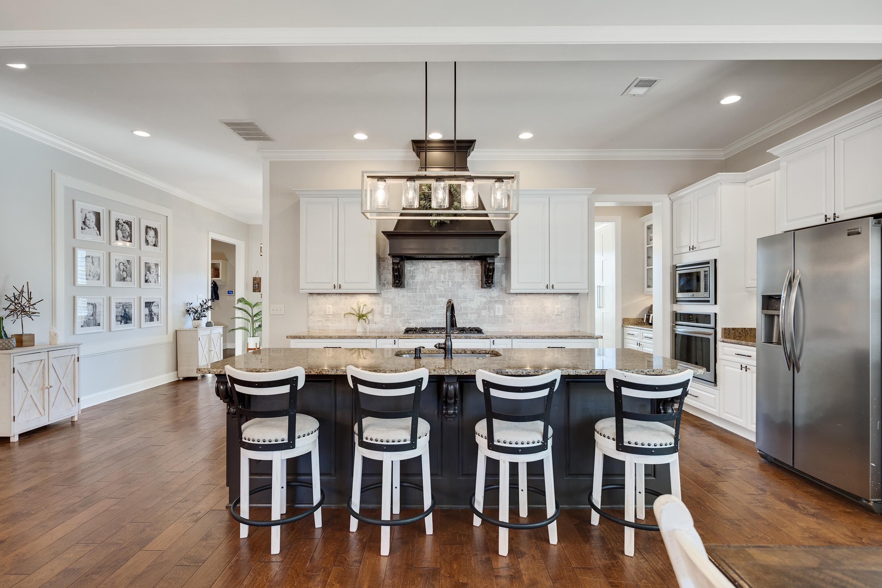 10062 Morning Cross Lane Collierville, TN 38017 - Photo 17 of 39 a kitchen with stainless steel appliances a dining table chairs and wooden floor