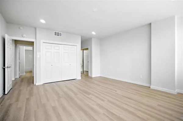 a view of an empty room with wooden floor