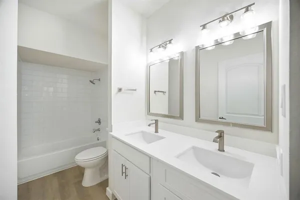 a bathroom with a sink a toilet and a large mirror