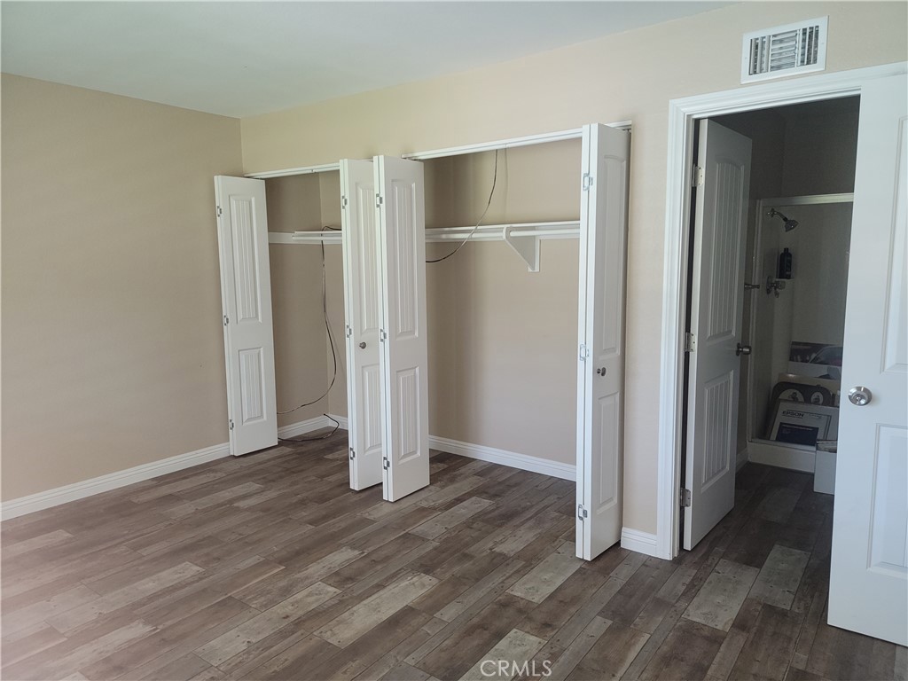 4464 Clarksdale Drive Riverside, CA 92505 - Photo 18 of 23 a view of an empty room with wooden floor and a bathroom