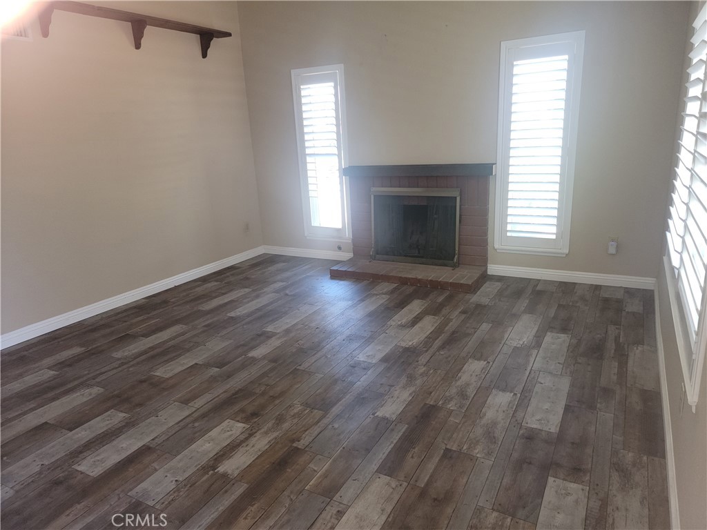 4464 Clarksdale Drive Riverside, CA 92505 - Photo 3 of 23 an empty room with wooden floor fireplace and windows