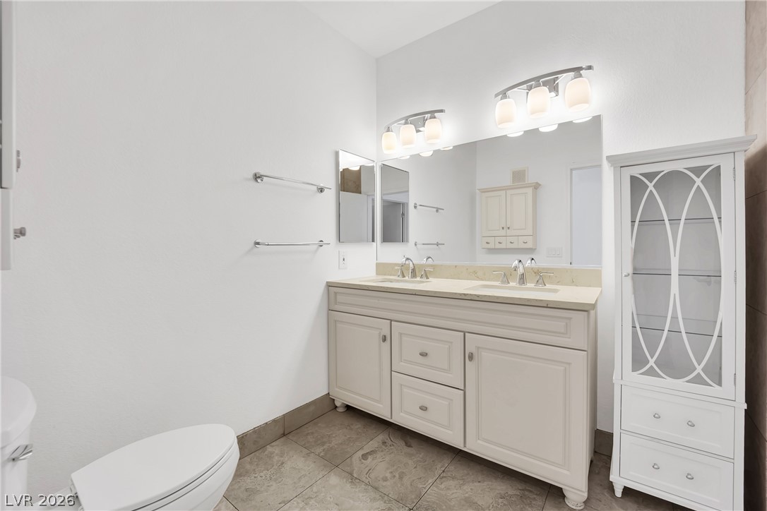 8725 West Flamingo Road, Unit 110 Las Vegas, NV 89147 - Photo 7 of 30 A well-appointed primary bathroom showcases dual vanities with ample counter space and elegant cabinetry.