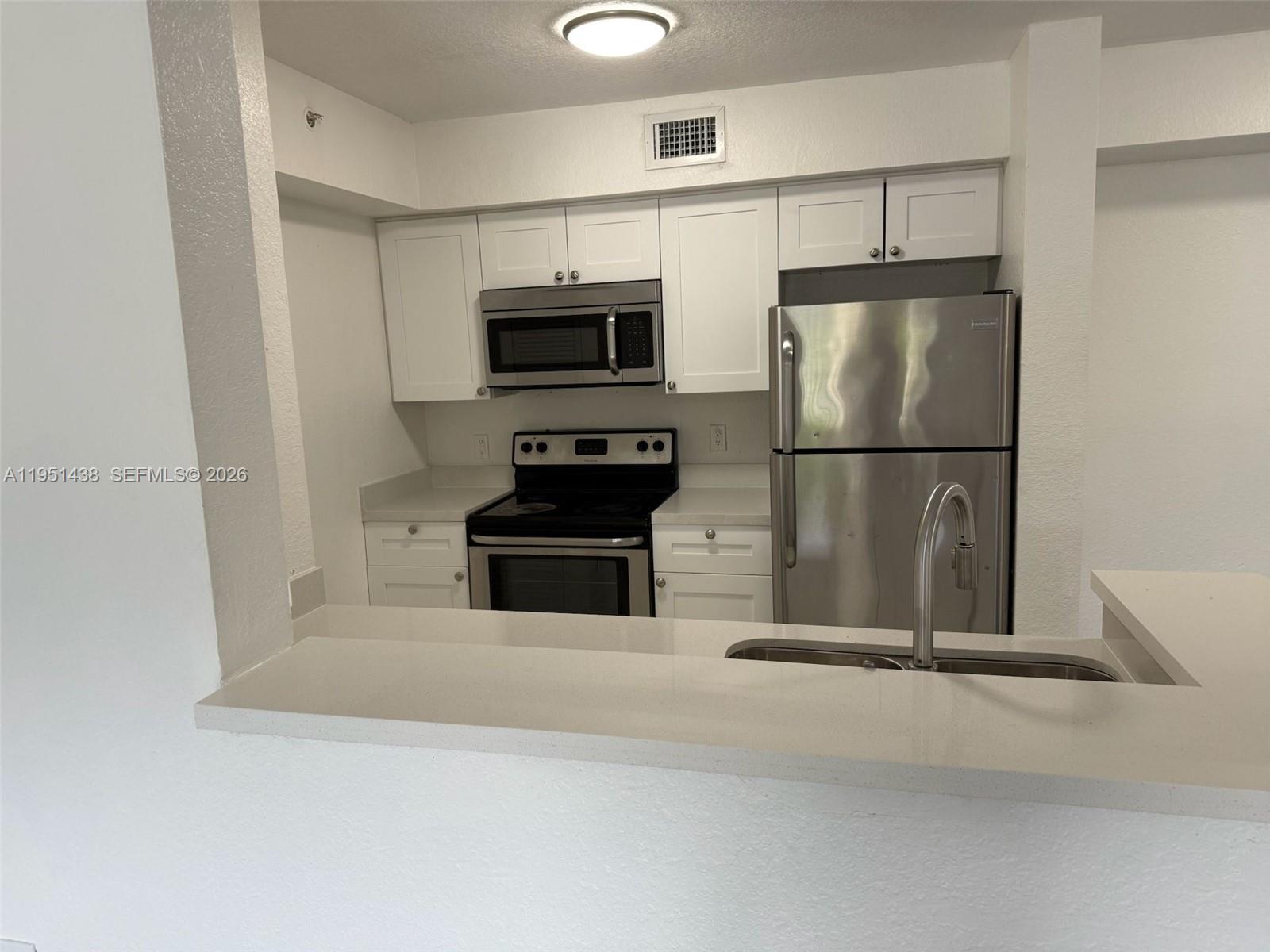 15410 Southwest 284th Street, Unit 8203 Homestead, FL 33033 - Photo 13 of 21 a kitchen with stainless steel appliances a refrigerator and microwave