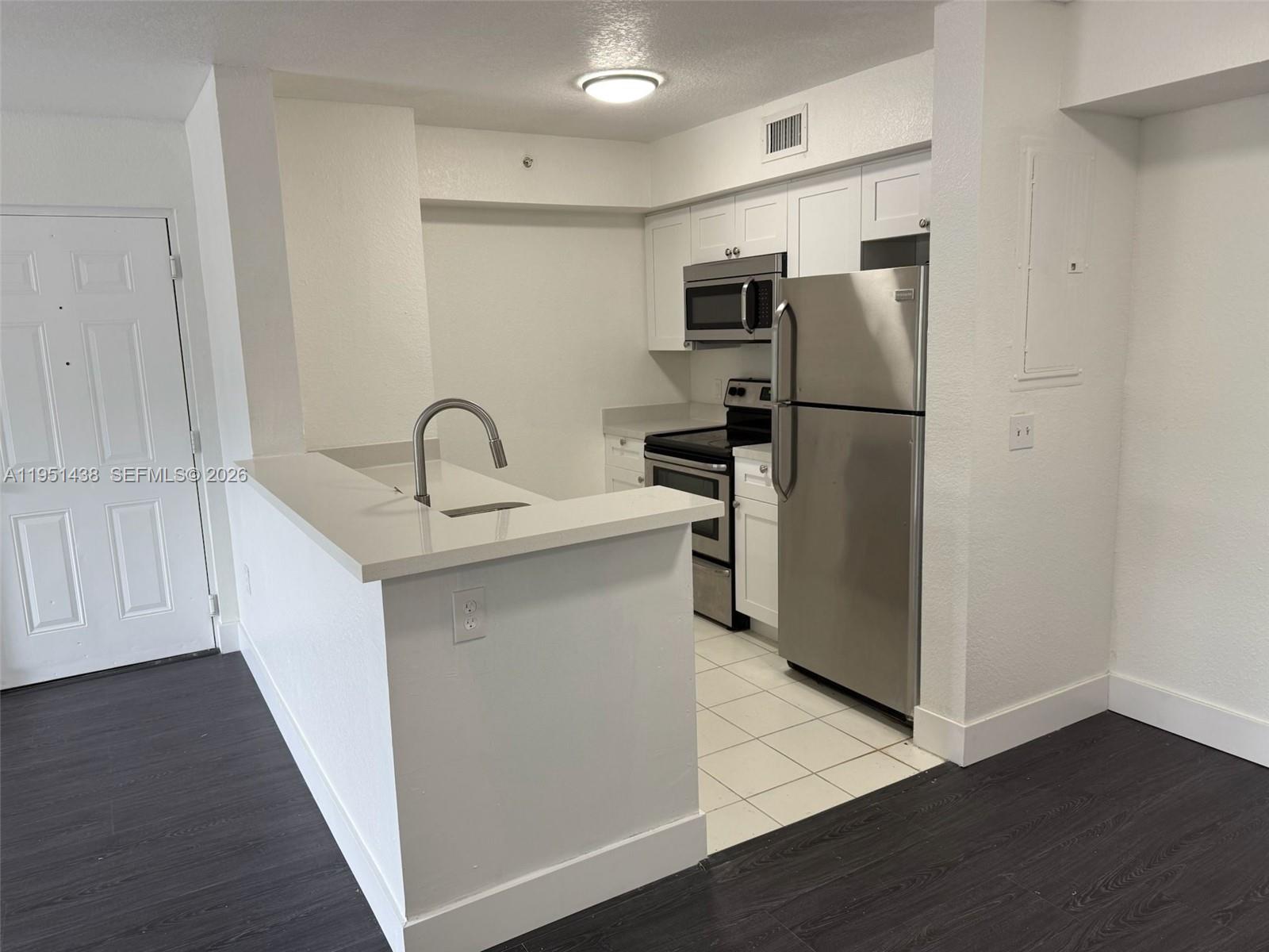 15410 Southwest 284th Street, Unit 8203 Homestead, FL 33033 - Photo 15 of 21 a kitchen with a refrigerator sink and cabinets