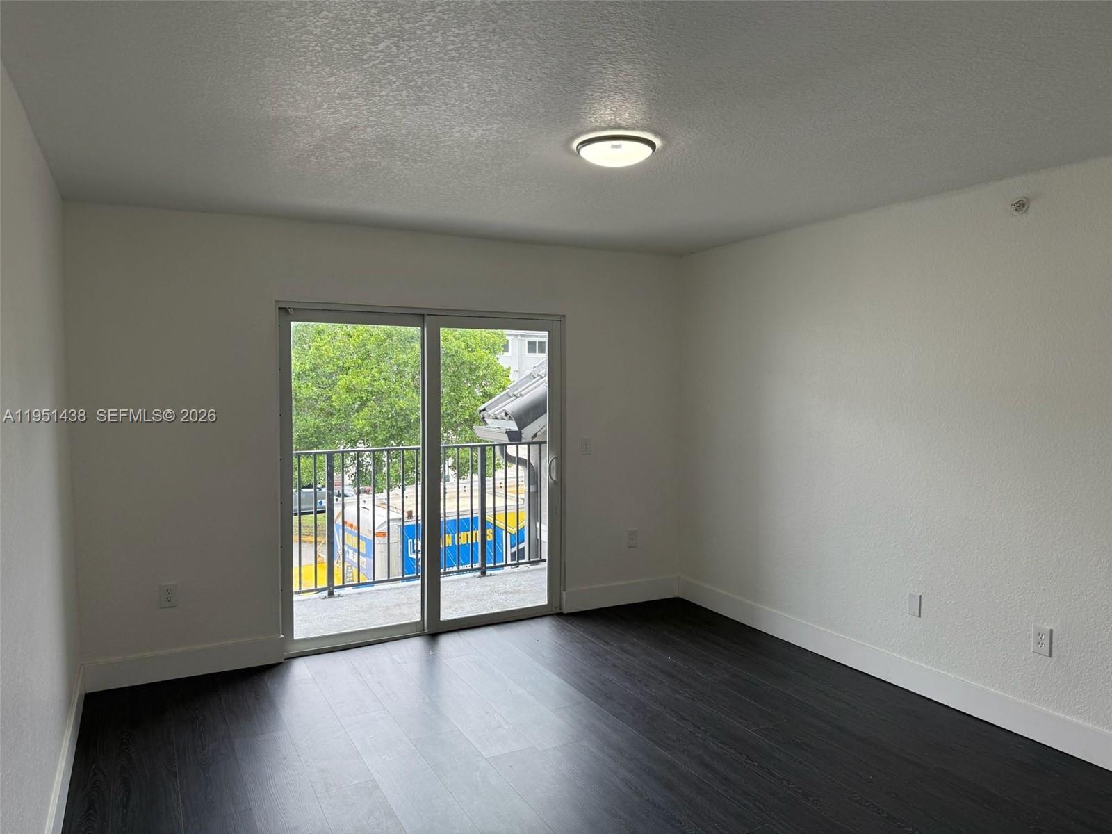 15410 Southwest 284th Street, Unit 8203 Homestead, FL 33033 - Photo 20 of 21 a view of an empty room with wooden floor and a window