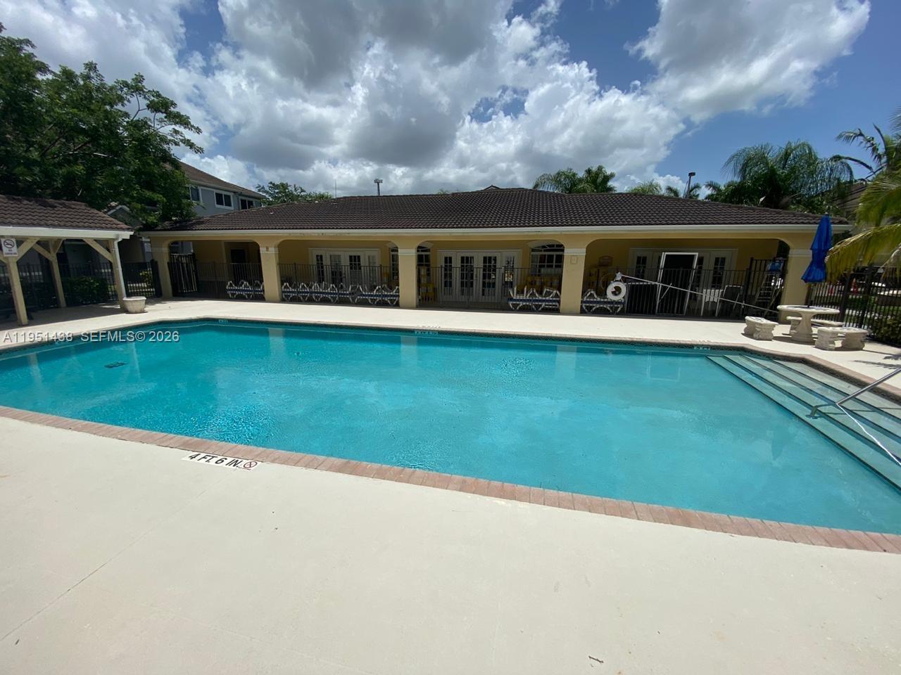 15410 Southwest 284th Street, Unit 8203 Homestead, FL 33033 - Photo 2 of 21 a front view of a house with swimming pool having outdoor seating