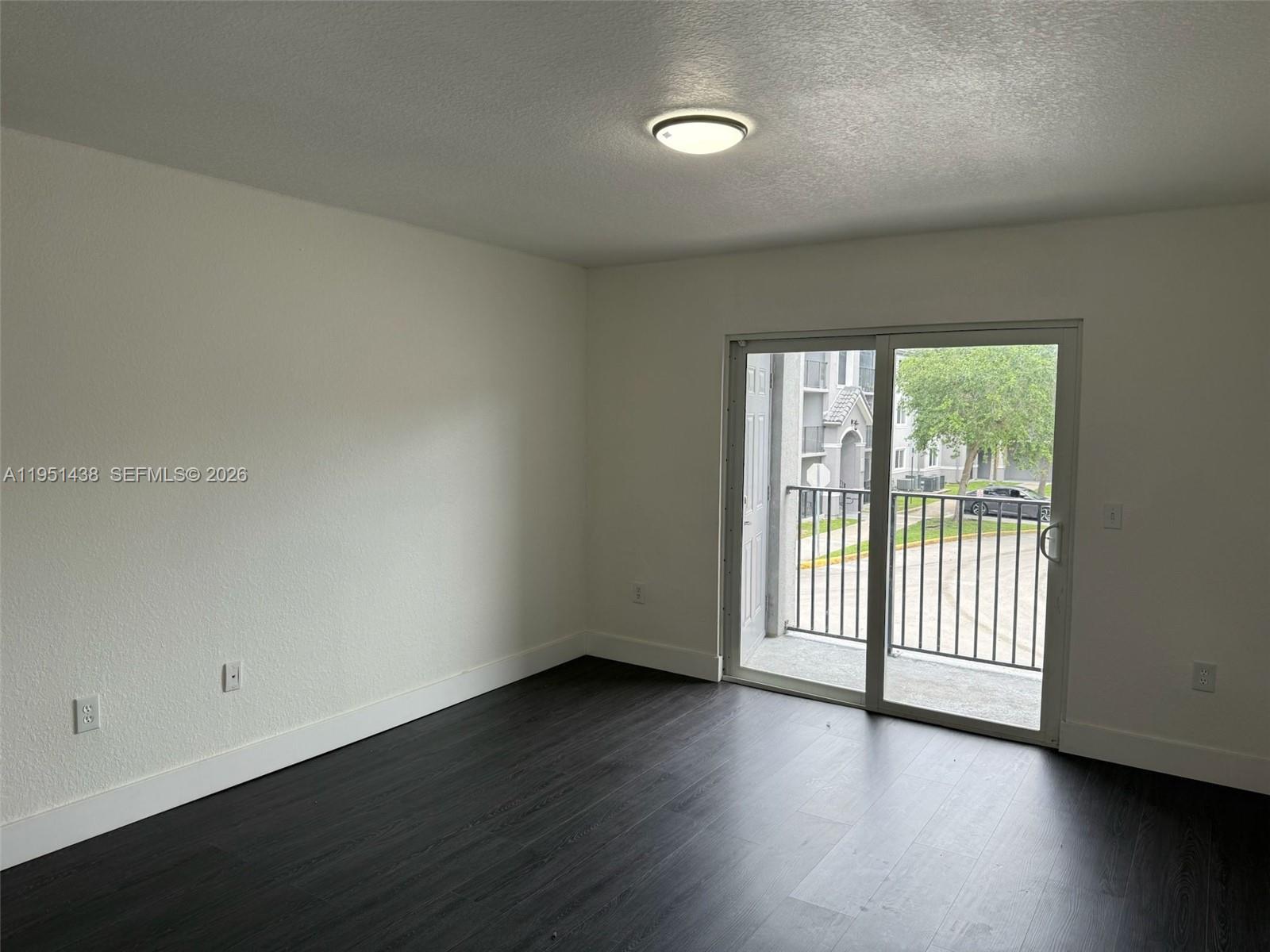 15410 Southwest 284th Street, Unit 8203 Homestead, FL 33033 - Photo 21 of 21 an empty room with wooden floor and windows