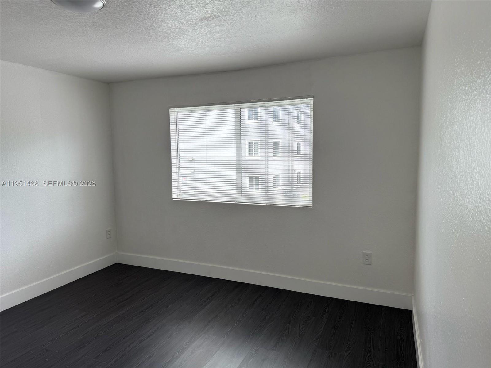 15410 Southwest 284th Street, Unit 8203 Homestead, FL 33033 - Photo 4 of 21 an empty room with wooden floor and windows