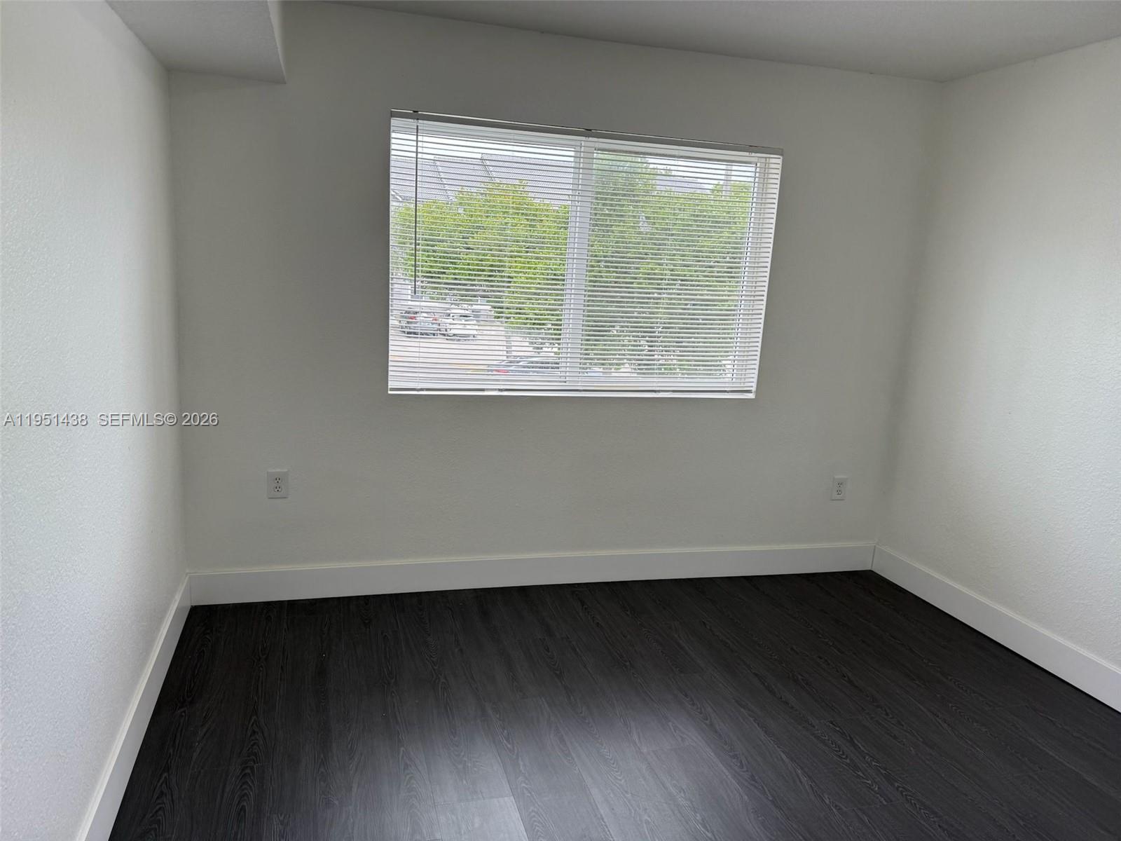 15410 Southwest 284th Street, Unit 8203 Homestead, FL 33033 - Photo 7 of 21 an empty room with wooden floor and windows