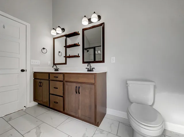 a bathroom with a toilet sink and mirror