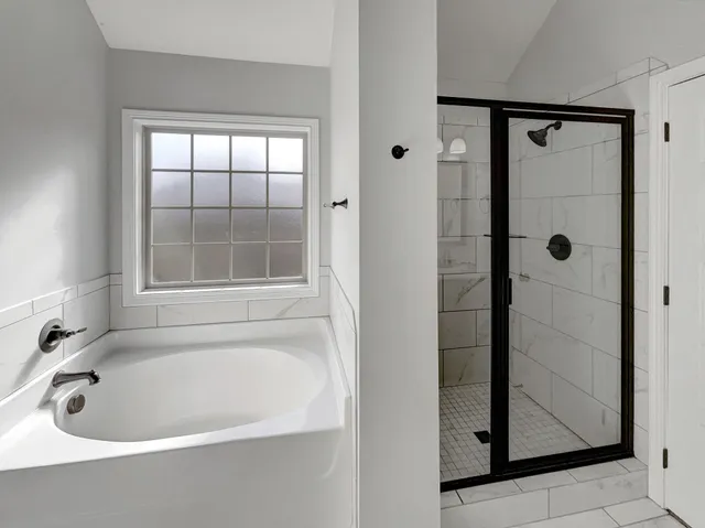 a white bath tub sitting next to a shower