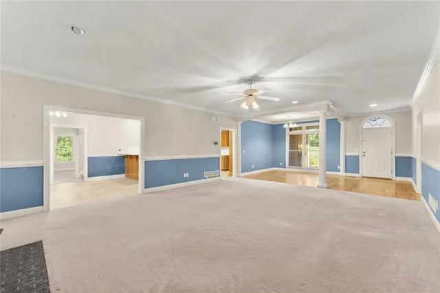 an empty room with a window and a ceiling fan