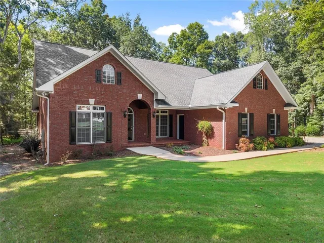 a view of a livingroom with a ceiling fan wooden floor and fireplace