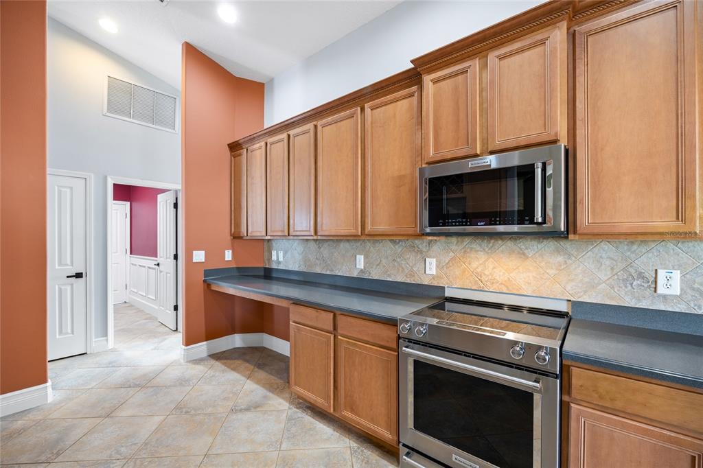 13413 Mandalay Place Spring Hill, FL 34609 - Photo 16 of 46 a kitchen with stainless steel appliances a stove microwave and sink