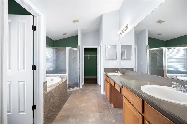 a spacious bathroom with a granite countertop tub sink and mirror