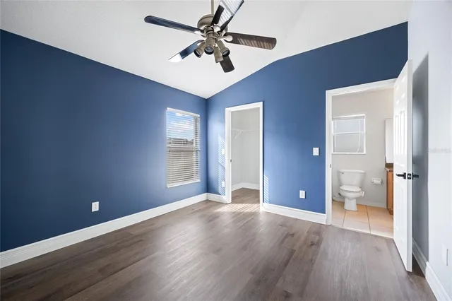 a view of a big room with wooden floor and a ceiling fan