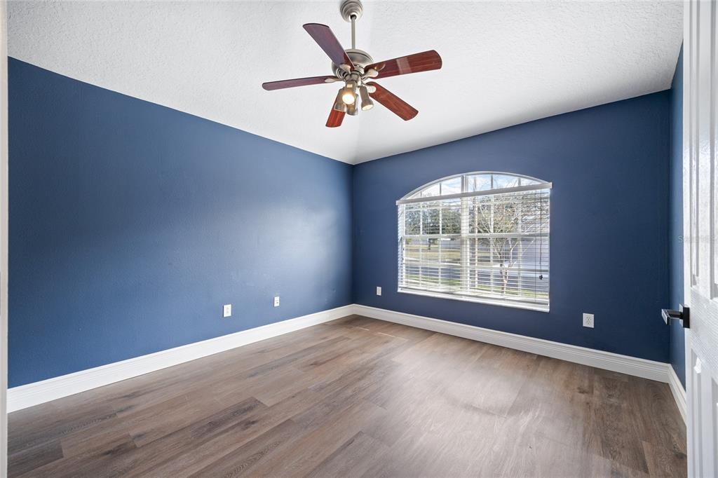 13413 Mandalay Place Spring Hill, FL 34609 - Photo 8 of 46 a view of an empty room with wooden floor and a window