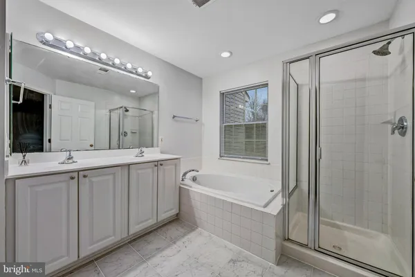 a bathroom with a tub a sink and mirrors