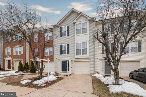 a view of a white house with a large tree