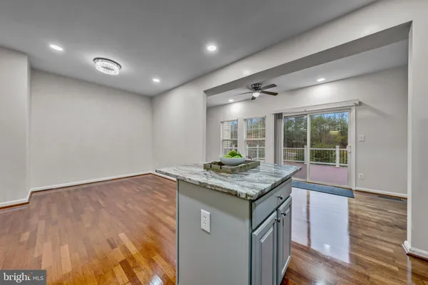 a kitchen with stainless steel appliances granite countertop a sink window and wooden floor