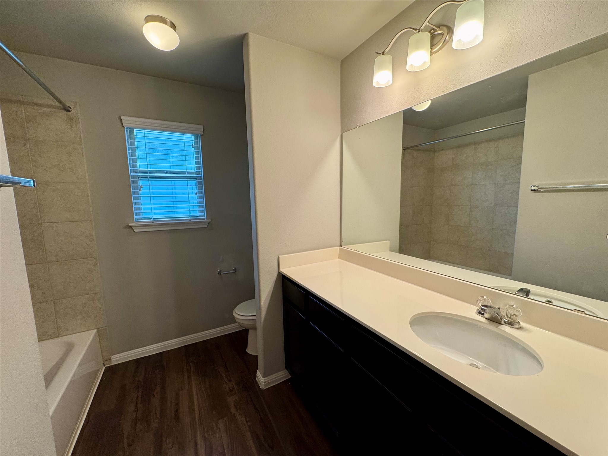 219 Wapiti Road Buda, TX 78610 - Photo 20 of 24 Full bath featuring vanity, dark wood-type flooring, and bathing tub / shower combination