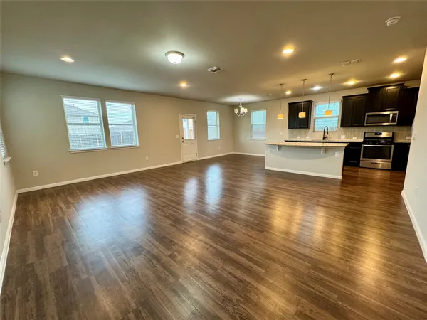 a kitchen with kitchen island granite countertop a sink stove and refrigerator