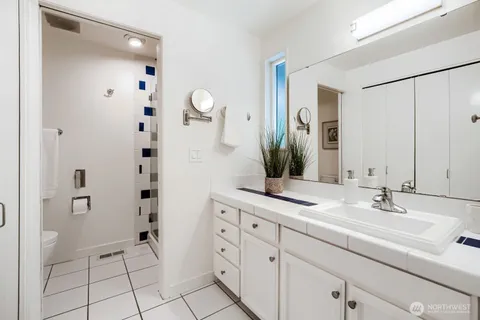 a bathroom with a double vanity sink mirror and shower