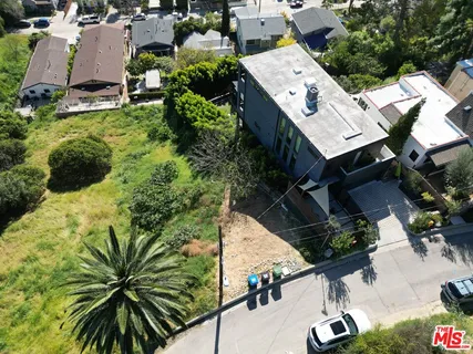 an aerial view of residential house with outdoor space and trees all around