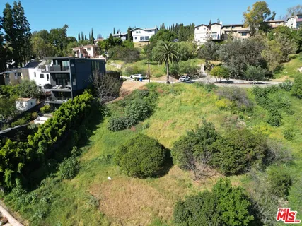 an aerial view of residential house with outdoor space and trees all around