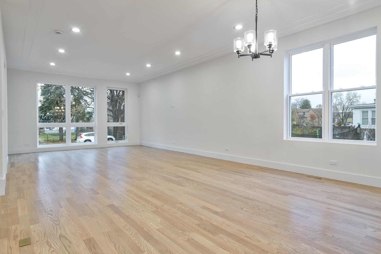 3015 North Normandy Avenue Chicago, IL 60634 - Photo 8 of 28 an empty room with wooden floor and large windows