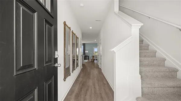 a view of a hallway with wooden floor and staircase