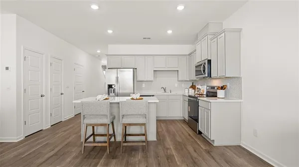 a kitchen with white cabinets and stainless steel appliances