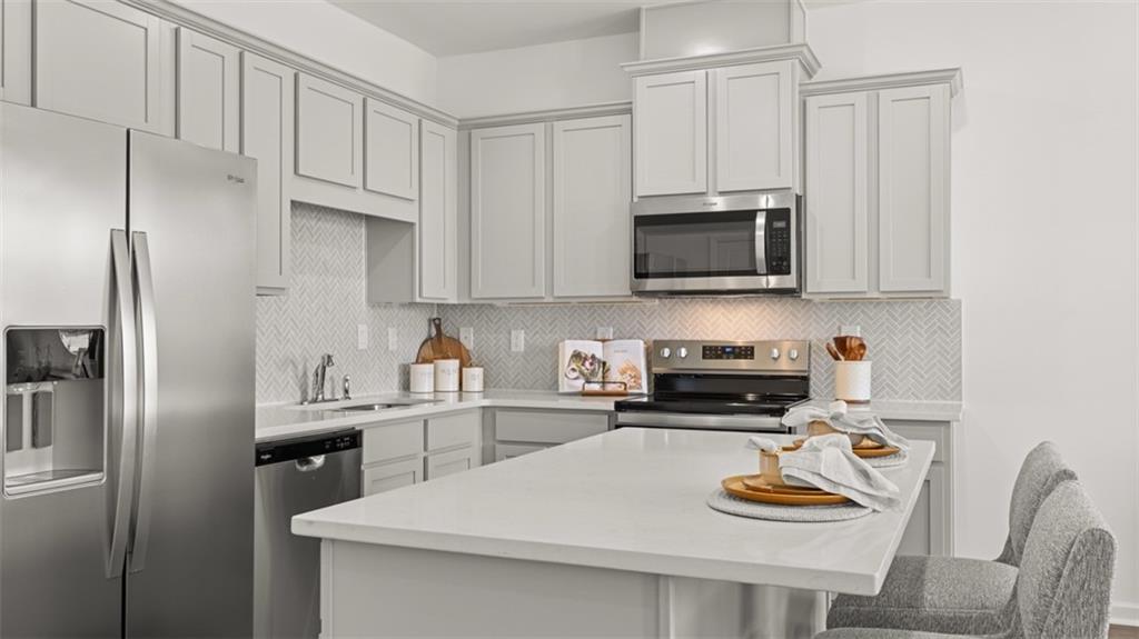 202 Kenmore Circle Perry, GA 31069 - Photo 10 of 47 a kitchen with stainless steel appliances a stove a sink and a microwave