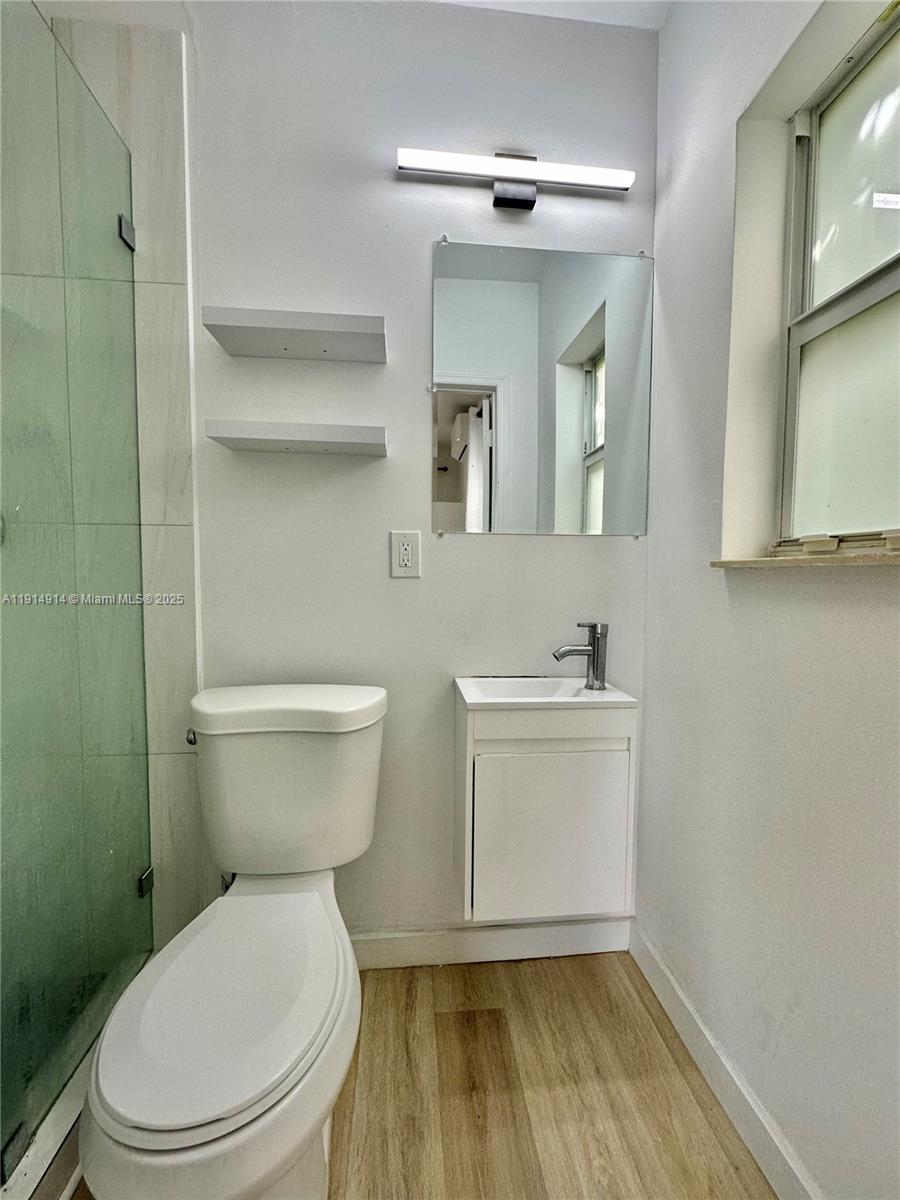 415 75th Street, Unit 1A Miami Beach, FL 33141 - Photo 11 of 19 a white toilet sitting next to a bathroom sink