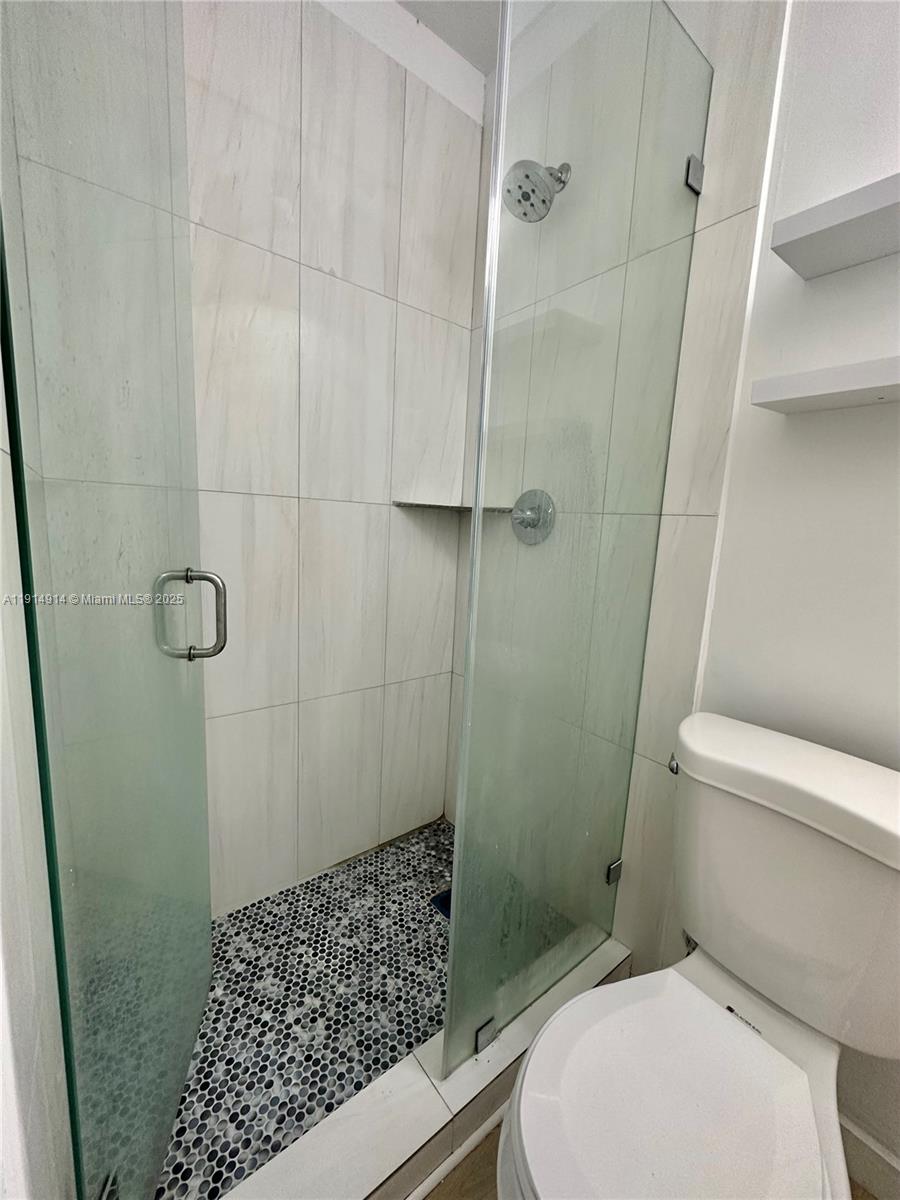 415 75th Street, Unit 1A Miami Beach, FL 33141 - Photo 12 of 19 a bathroom with a toilet and shower