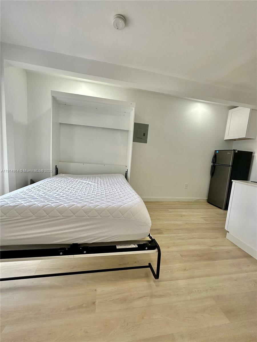 415 75th Street, Unit 1A Miami Beach, FL 33141 - Photo 6 of 19 a bedroom with a bed and lamp