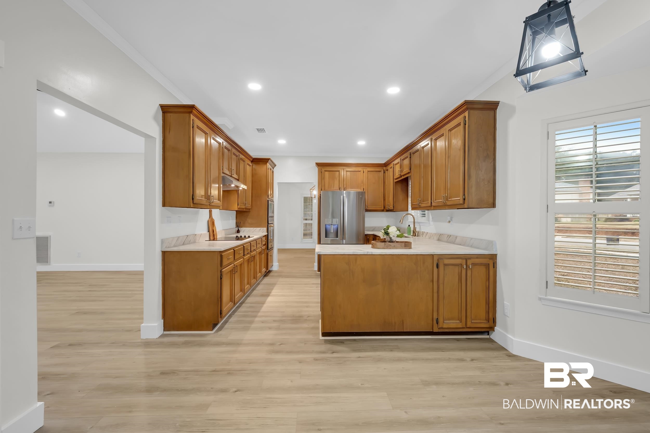 4924 Brooke Court Mobile, AL 36618 - Photo 12 of 34 Kitchen with a peninsula, brown cabinetry, light countertops, light wood-style flooring, and recessed lighting