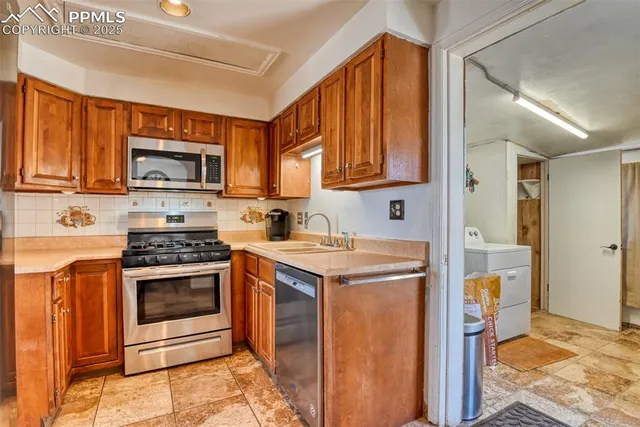 a kitchen with stainless steel appliances a stove a microwave a sink and cabinets