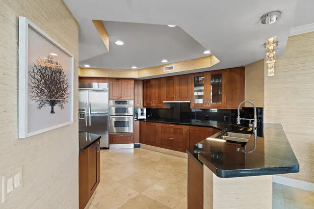 a kitchen with stainless steel appliances granite countertop a sink and a stove