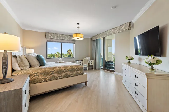 a spacious bedroom with a bed and a flat screen tv