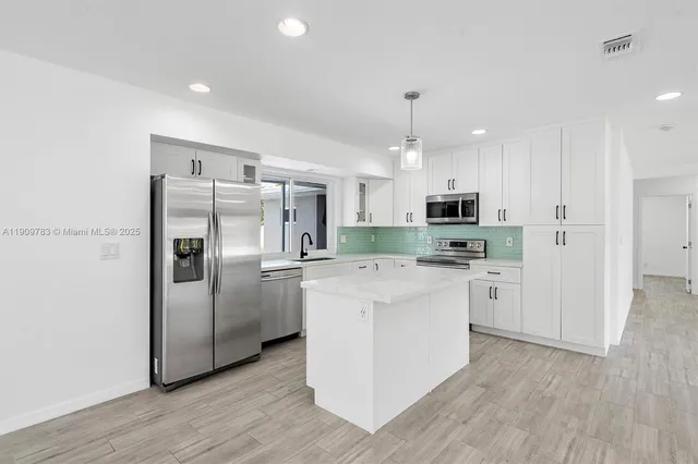 a kitchen with stainless steel appliances a refrigerator sink and microwave