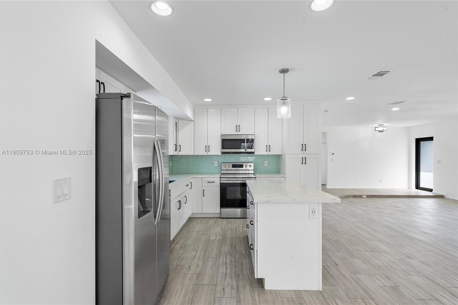 4309 Jackson Street Hollywood, FL 33021 - Photo 13 of 39 a large kitchen with stainless steel appliances kitchen island a stove a refrigerator a sink and a refrigerator