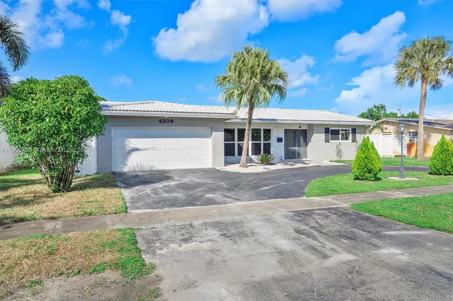 a front view of a house with a yard and a garage