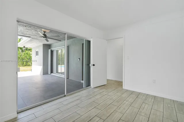 a view of a big room with windows and chandelier fan