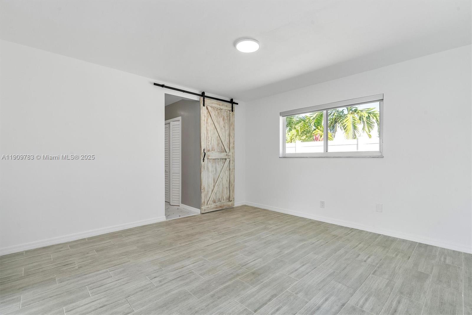 4309 Jackson Street Hollywood, FL 33021 - Photo 27 of 39 an empty room with wooden floor and windows